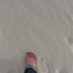 The author's feet in the white sand. Photo copyright Sara J. Bruegel, 2016