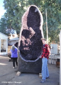 A large geode with a slightly taller than average man.  Photo copyright Sara J. Bruegel, 2016